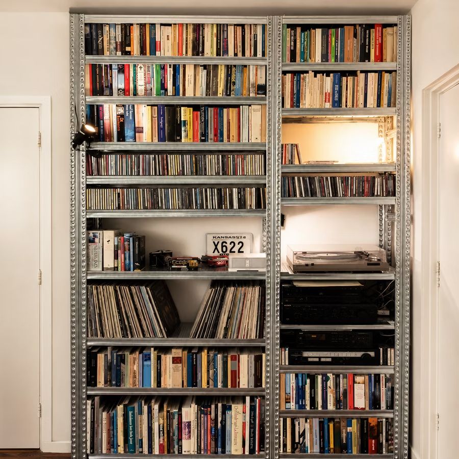 Hoge metalen boekenkast volledig gevuld met boeken in een wooninterieur