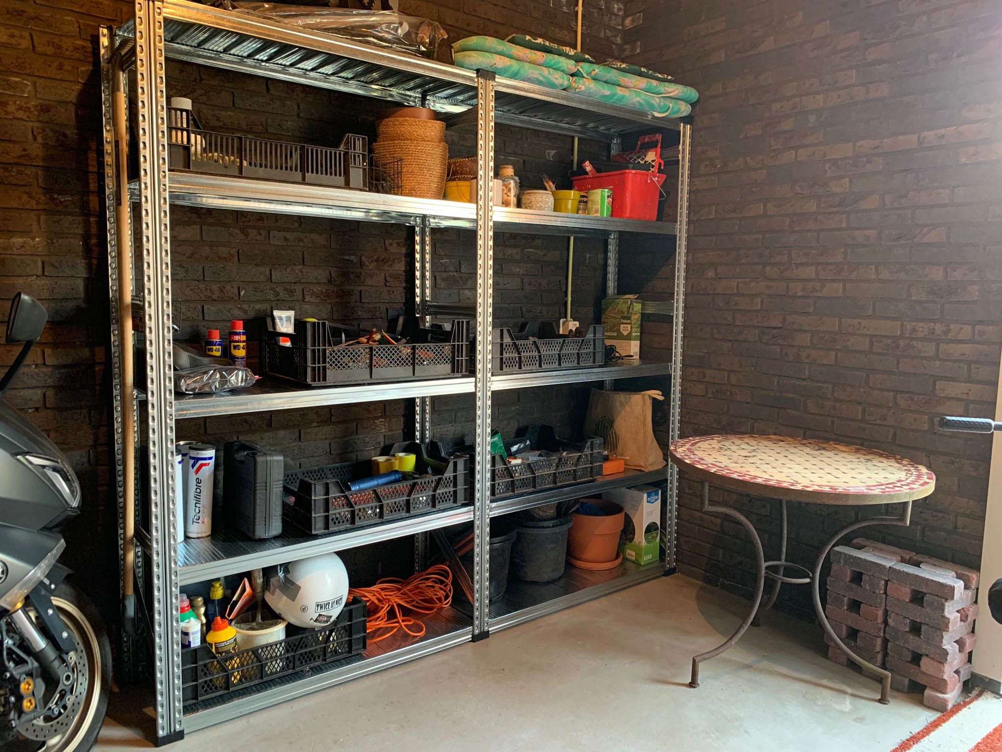 Garage of schuur ingericht met metalen stellingkasten voor gereedschap en voorraad
